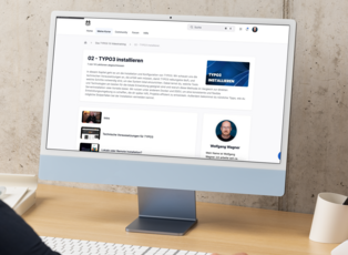 Auf dem Bild sieht man einen Computerbildschirm, der eine Website mit einem Videokurs über die Installation von TYPO3 anzeigt. Der Kurs beinhaltet mehrere Kapitel, darunter technische Voraussetzungen und Tipps zur Installation. Der Kursleiter heißt Wolfgang Wagner.
